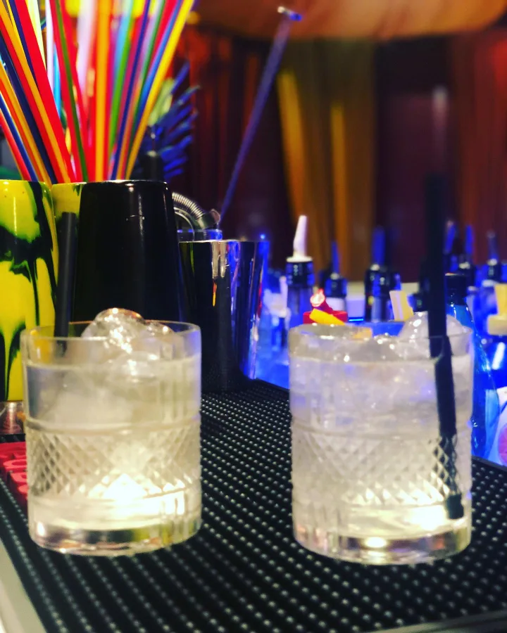 Two highball cocktails in Maitai Club blue light.